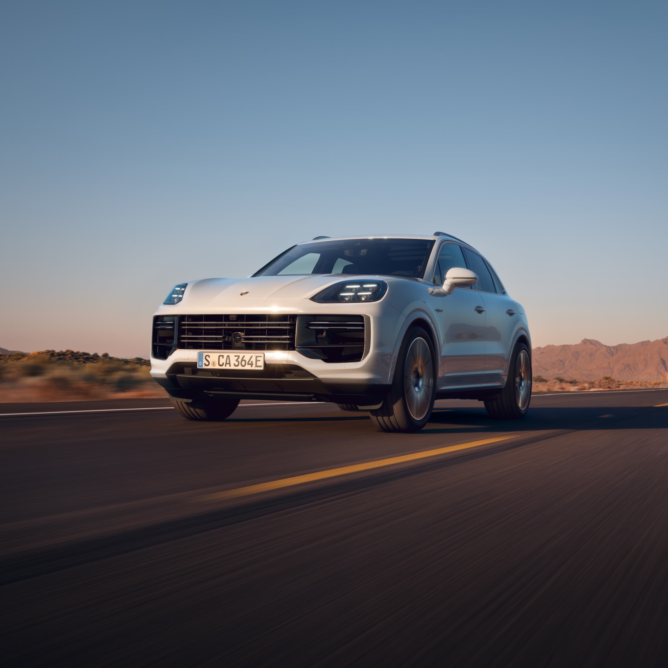 Ein Porsche Cayenne fährt auf offener Straße.